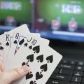 Laptop önünde elinde iskambil kağıtları tutan adam